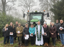 The congregation outside in the mist alter the blessing of a tractor.